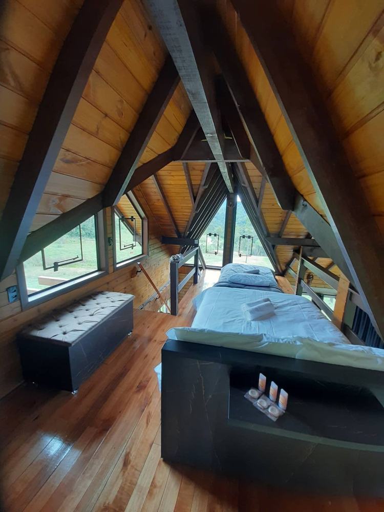 Vista do mezanino, com a cama de casal e o puff baú